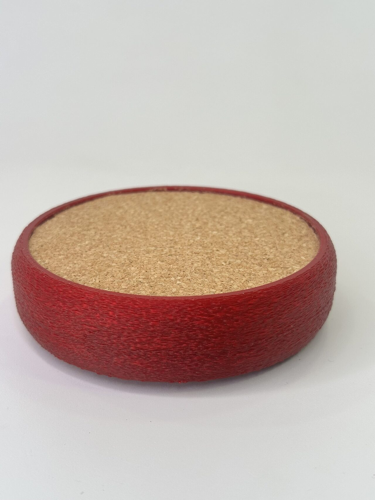 Red printed coaster with a cork top, on a white background