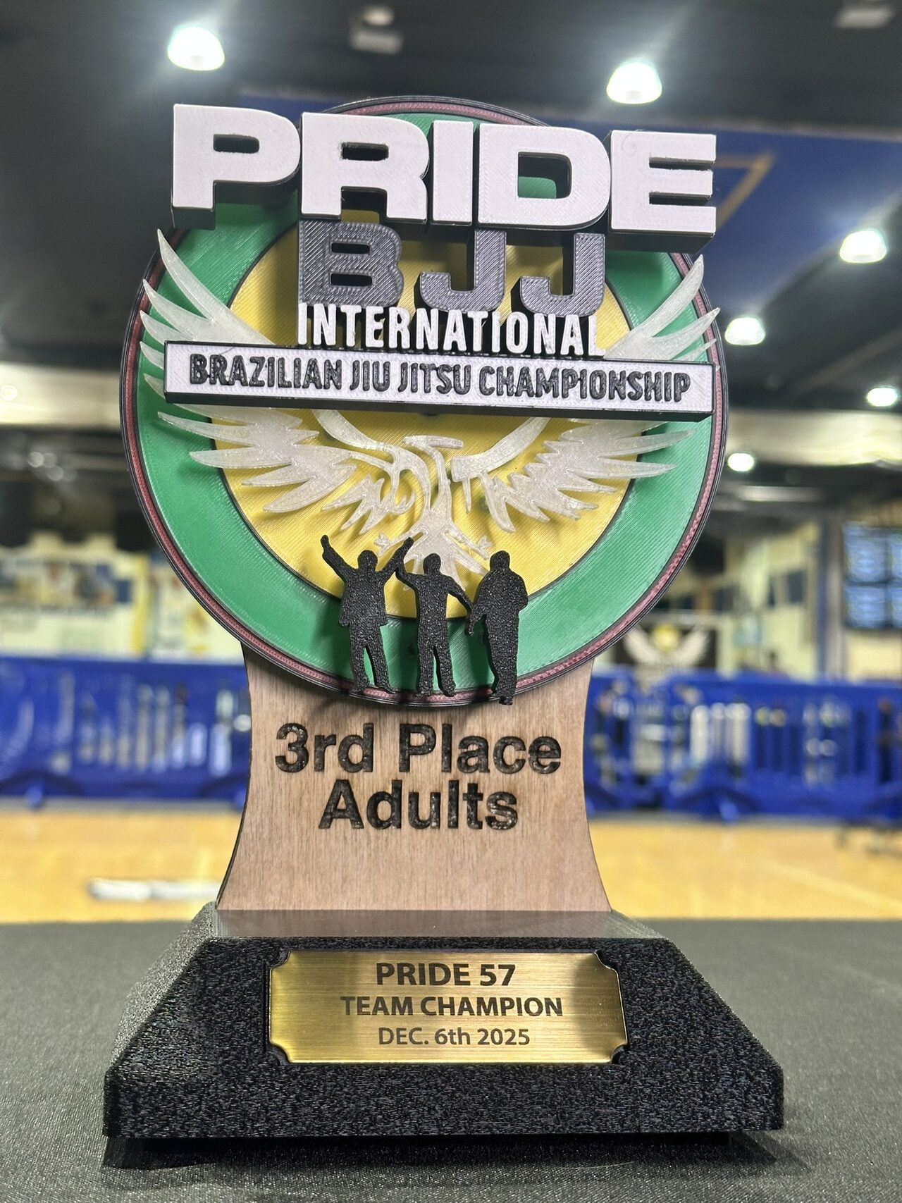 Close view of the 3rd Place Adults trophy; the plate on its black base reads Pride 57 Team Champion, Dec. 6th 2025.