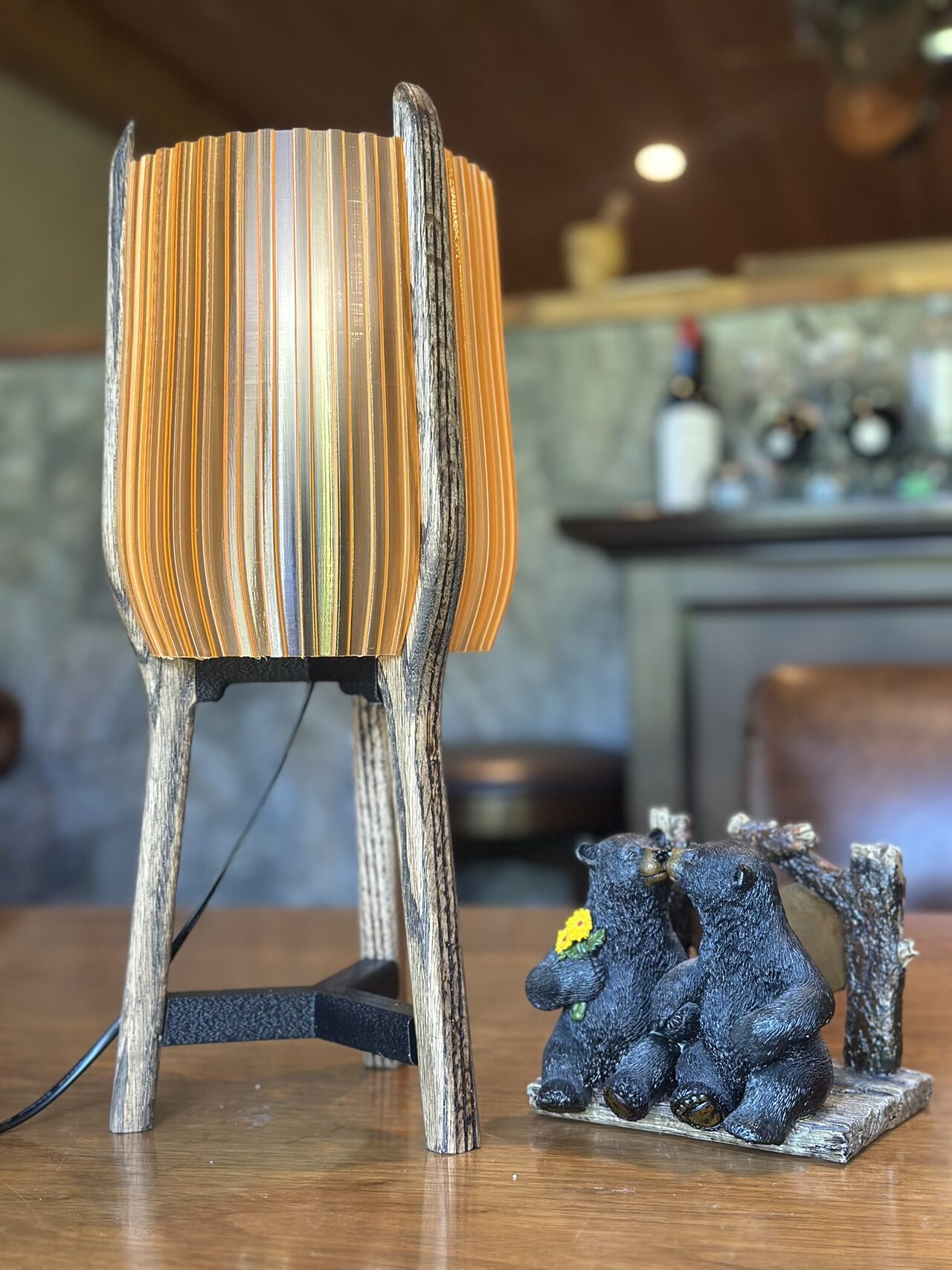 The lamp with its amber shade switched off, seen at a three-quarter angle beside a small bear figurine